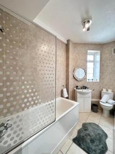 a bathroom with a tub and a toilet and a sink at Light Budget Studio Apartment on Edgware Road, Central London in London