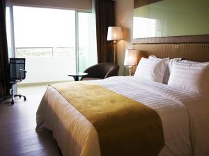 a hotel room with a large bed and a window at Garden Sentral Hotel in Kuala Belait