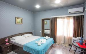 a bedroom with a bed with towels on it at Hotel Homeland in Batumi