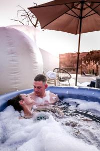 a man and a woman in a hot tub at The Bubble Valley clarens in Clarens