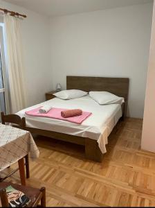 a bedroom with a bed with a pink blanket on it at Apartments Vulić in Omiš