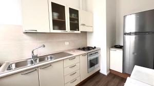 a kitchen with white cabinets and a stainless steel refrigerator at A34 - Ancona, delizioso bilocale in centro in Ancona