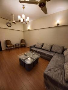 a living room with a couch and a table at Modern Luxury Guest Apartment With All Facilities in Karachi