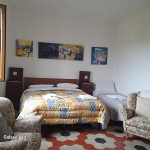 - une chambre avec un lit et deux chaises dans l'établissement villart, à Carbonara Scrivia