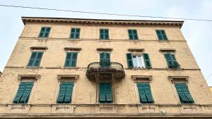 a tall building with green shuttered windows and a balcony at A34 - Ancona, delizioso bilocale in centro in Ancona