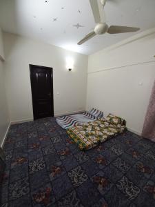 a bedroom with a bed and a ceiling fan at Modern Luxury Guest Apartment With All Facilities in Karachi