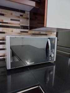 a microwave oven sitting on top of a counter at Modern Luxury Guest Apartment With All Facilities in Karachi