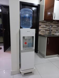 a small refrigerator with a water cooler in a kitchen at Modern Luxury Guest Apartment With All Facilities in Karachi