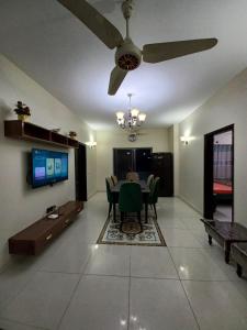 a living room with a table and a ceiling fan at Modern Luxury Guest Apartment With All Facilities in Karachi