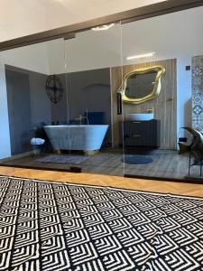 a bathroom with a tub and a glass wall at Schiller Rooms in Sibiu