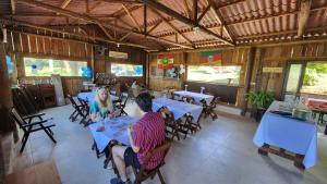 a group of people sitting at tables in a restaurant at Fazenda Serramar in Palhoça