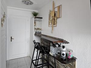 een keuken met een zwart aanrecht en 2 stoelen bij Sweet Crépuscule - Studio avec Vue Mer Imprenable & Piscine in Les Trois-Îlets