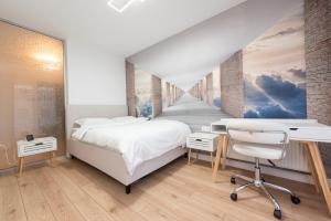 a bedroom with a bed and a desk and a hallway at ART Apartment III in Târgu-Mureş
