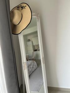 a straw hat sitting on top of a mirror at Vanilla Studio in Bar