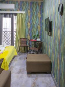 a bedroom with a yellow bed and a table and chairs at Hotel Homeland in Batumi