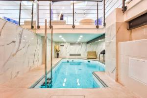 einen Pool in einem Gebäude mit einer Decke in der Unterkunft Deauville Luxury Blue Loft - sauna and inside pool in Trouville-sur-Mer