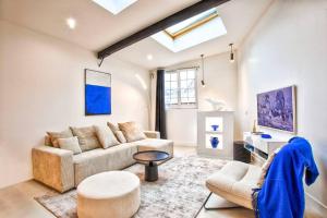 ein Wohnzimmer mit Sofa und Tisch in der Unterkunft Deauville Luxury Blue Loft - sauna and inside pool in Trouville-sur-Mer