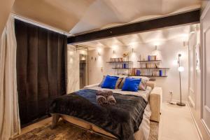 ein Schlafzimmer mit einem großen Bett mit blauen Kissen in der Unterkunft Deauville Luxury Blue Loft - sauna and inside pool in Trouville-sur-Mer + 24 Fotos