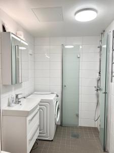 a white bathroom with a washing machine and a sink at RANTA in Tampere +14 photos