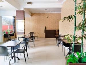 um restaurante com mesas e cadeiras num quarto em Hotel Labuhan Raya em Medan