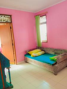 1 dormitorio con 1 cama en una pared de color rosa en Villa family Montana 3, en Cicadas