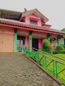 a pink house with a fence in front of it at Villa family Montana 3 in Cicadas
