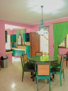 a dining room with a green table and chairs at Villa family Montana 3 in Cicadas