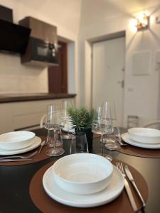 IN MEDIA URBE - intero appartamento في لاكويلا: طاولة عليها صحون واكواب للنبيذ