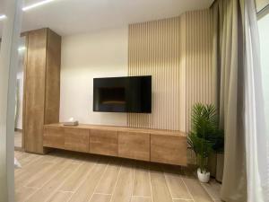 a living room with a television on a wall at Beach Experience Get-Away! in Trâblous