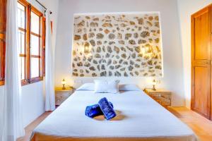 Un dormitorio con una cama con una toalla azul. en Casita de Montaña cerca del mar en Fornalutx