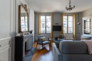 Una sala de estar con un sofá y una chimenea. en Appartements Du Clos Vorin, en Honfleur