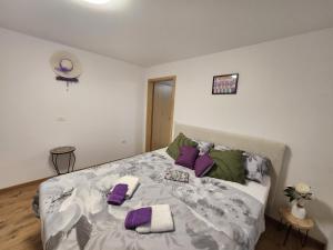 a bedroom with a bed with purple and green pillows at Apartma Aleksandra in Sečovlje