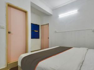 een witte kamer met een bed en een deur bij Collection O Goa Savera Holiday Homes in Nerul