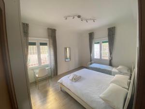 a bedroom with a bed and a chair and two windows at Enjoy in Lido di Ostia
