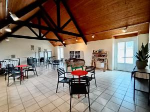a room with tables and chairs in a room with wooden ceilings at Camping de La Hallerais**** in Taden
