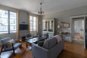 una sala de estar con un sofá y una mesa en Appartements Du Clos Vorin, en Honfleur