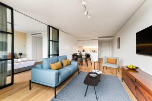 uma sala de estar com um sofá azul e uma mesa em Mirabilis Apartments - LX Living em Lisboa