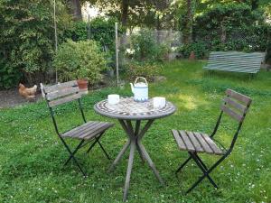 einen Tisch mit 2 Stühlen und einen Tisch mit einem Korb darauf in der Unterkunft le petit chemin in Bougival