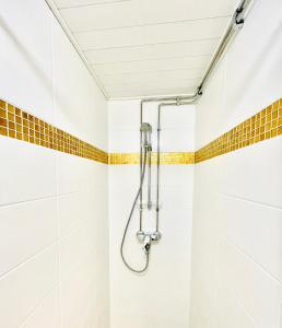 un bagno con doccia e piastrelle bianche di Stay Here Apartment Liisa a Helsinki