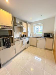 a kitchen with white appliances and a tile floor at Luxury 3 Bedroom House With FREE Parking in Dinnington