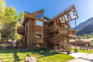 a log cabin with a staircase in the front yard at Alpenglow Unit 3 in Ouray