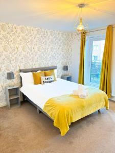 a bedroom with a large bed with a yellow blanket at Luxury 3 Bedroom House With FREE Parking in Dinnington