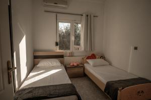 1 dormitorio con 2 camas y ventana en Albireo Luxury Villa, en La Canea