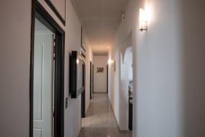 un pasillo con paredes blancas y una puerta con luz en Albireo Luxury Villa, en La Canea