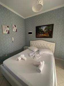a bedroom with a white bed with towels on it at Mirela’s Apartment City Center in Tirana