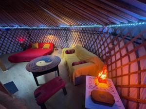 una habitación con 2 camas y una mesa en una yurta en Les songes du chêne, en Augirein