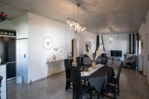 comedor con mesa y sillas en Albireo Luxury Villa, en La Canea