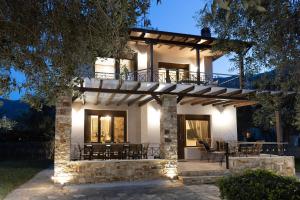 斯卡拉伯塔麦斯Villa Bellissimo的房屋设有门廊,配有桌椅