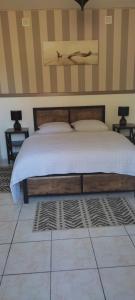 1 dormitorio con 1 cama con cabecero de madera en Gîte Domangé-Audenge en Audenge