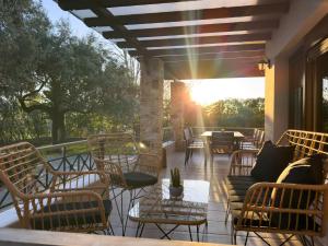 a patio with chairs and tables and the sun setting at Villa Bellissimo in Skala Potamias